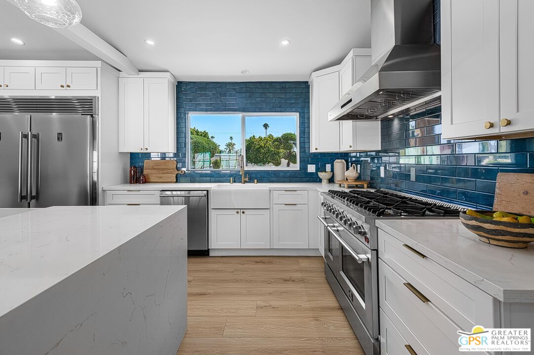 1433 North Fiesta Road Palm Springs, CA 92262 - Photo 10 of 30 a kitchen with a stove a sink a refrigerator and a cabinets
