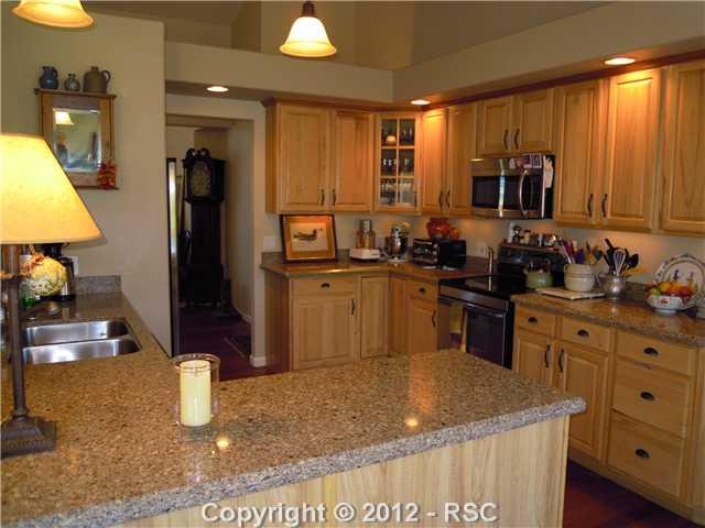 1075 Bowstring Road Monument, CO 80132 - Photo 7 of 16 The grandfather clock is in the hall that goes to the dining room on the left and the office, laundry, bath and garage are off to the right.
