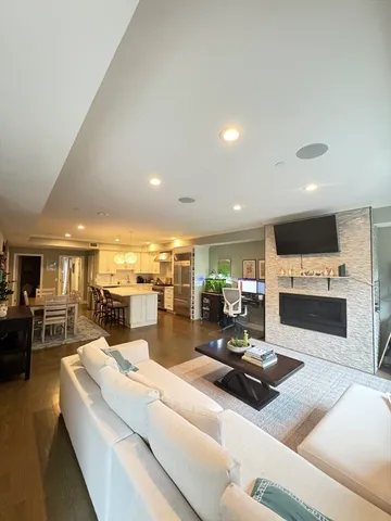 a living room with stainless steel appliances kitchen island granite countertop a sink and living room view