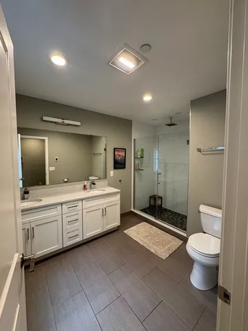 a bathroom with a double vanity sink toilet mirror and bathtub