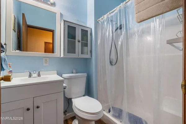a bathroom with a toilet sink vanity and mirror