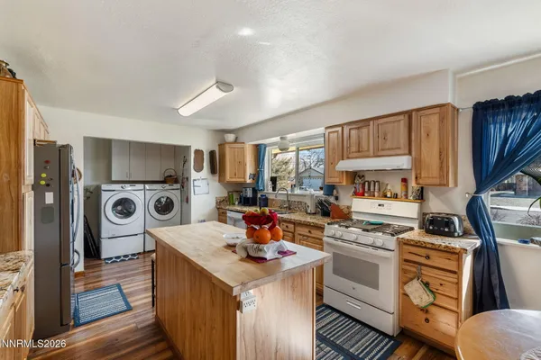 a kitchen that has a sink a stove and a refrigerator