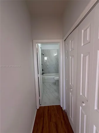 a view of a hallway with wooden floor