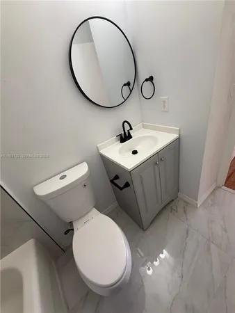 a bathroom with a sink mirror and toilet