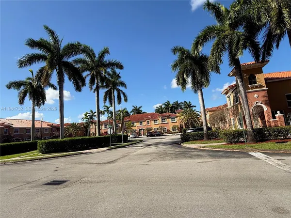 a row of palm trees next to a yard