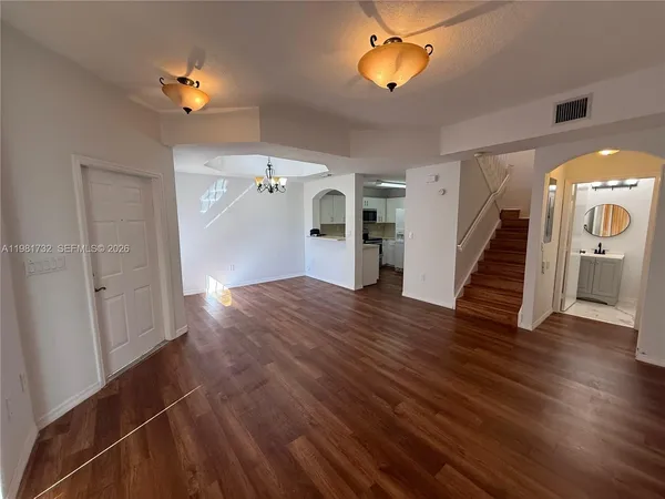 a view of a livingroom with wooden floor and a staircase
