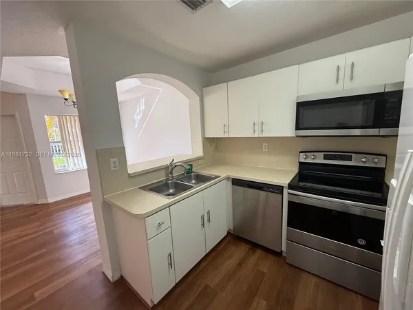 a kitchen with stainless steel appliances granite countertop a stove microwave and sink