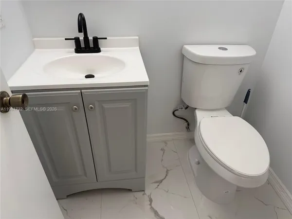a white toilet sitting next to a sink