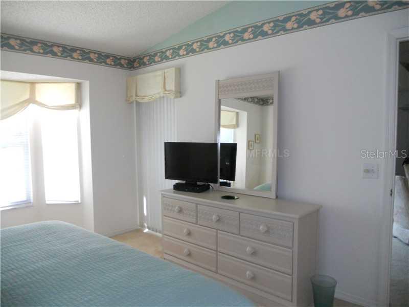 8911 Veranda Way, Unit 222 Sarasota, FL 34238 - Photo 11 of 25 a living room with flat screen tv on dresser and a window