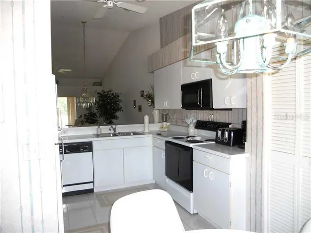 a kitchen with stainless steel appliances a sink a counter top space and a large window