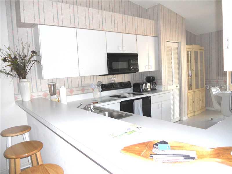 8911 Veranda Way, Unit 222 Sarasota, FL 34238 - Photo 4 of 25 a kitchen with stainless steel appliances a sink a counter top space and a large window