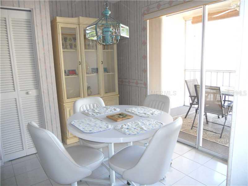 8911 Veranda Way, Unit 222 Sarasota, FL 34238 - Photo 5 of 25 a dining room with furniture a chandelier and wooden floor