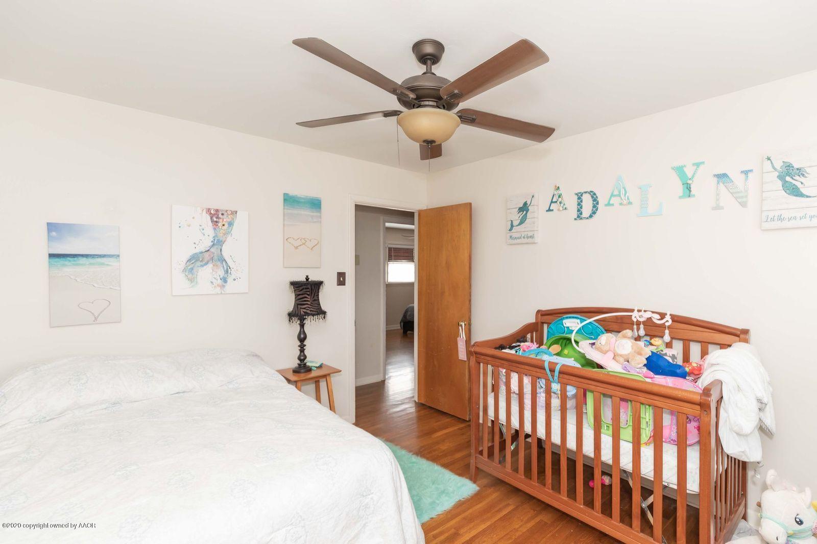 4701 South Milam Street Amarillo, TX 79110 - Photo 24 of 32 a bedroom with a bed and a chandelier