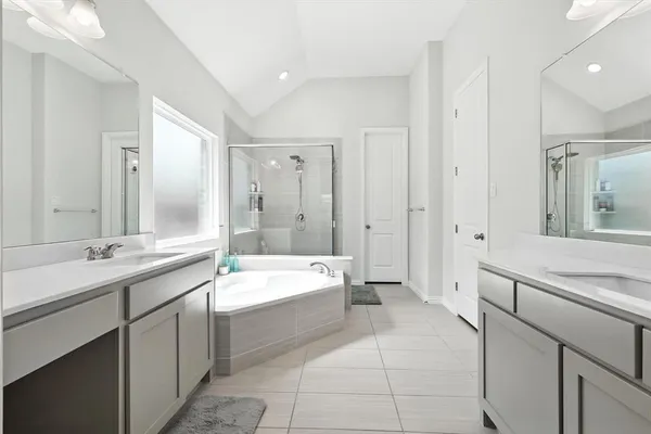 a bathroom with a tub sink shower and mirror
