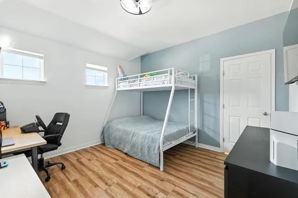 a bedroom with a bed and wooden floor
