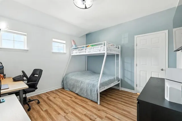 a bedroom with a bed and wooden floor