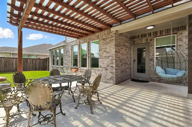 a view of a patio with table and chairs with wooden floor and fence