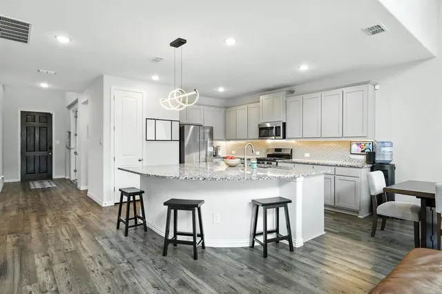 a kitchen with refrigerator cabinets dining table and chairs