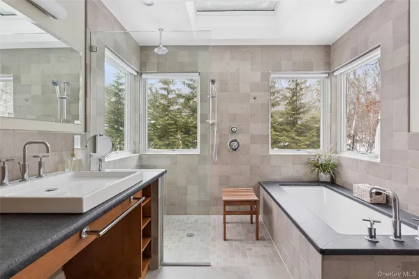 a bathroom with a granite countertop sink and a bathtub
