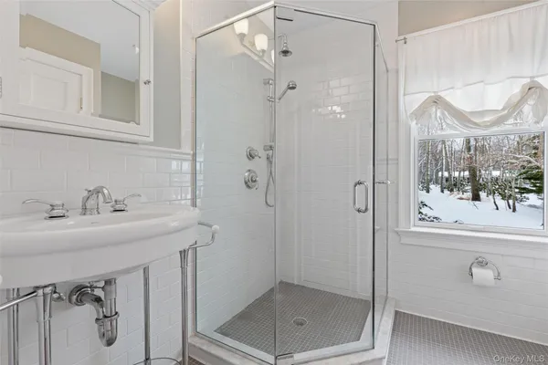 a bathroom with a shower sink and mirror