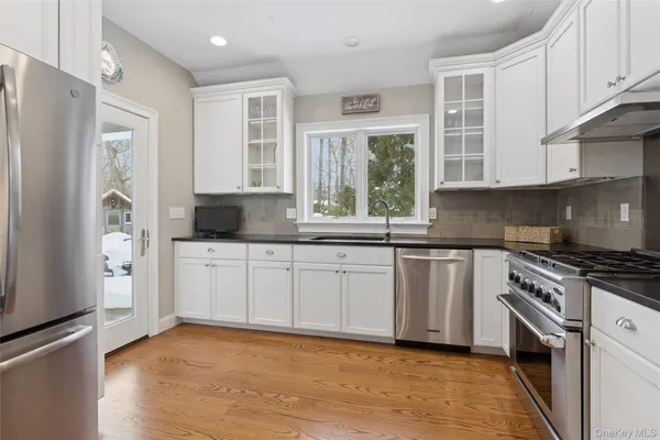 a kitchen with stainless steel appliances granite countertop a stove a sink and a refrigerator