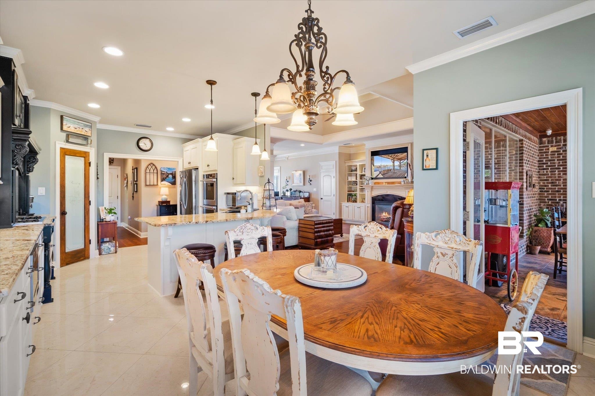 5683 Spring Landing Drive Theodore, AL 36582 - Photo 12 of 49 Dining area featuring crown molding, sink, light tile patterned floors, and a notable chandelier