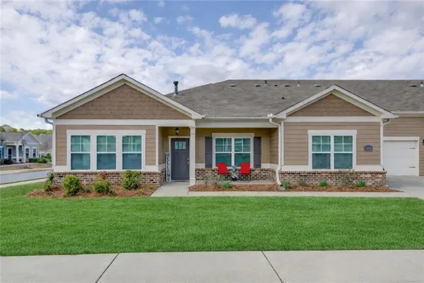 a front view of a house with a yard and trees