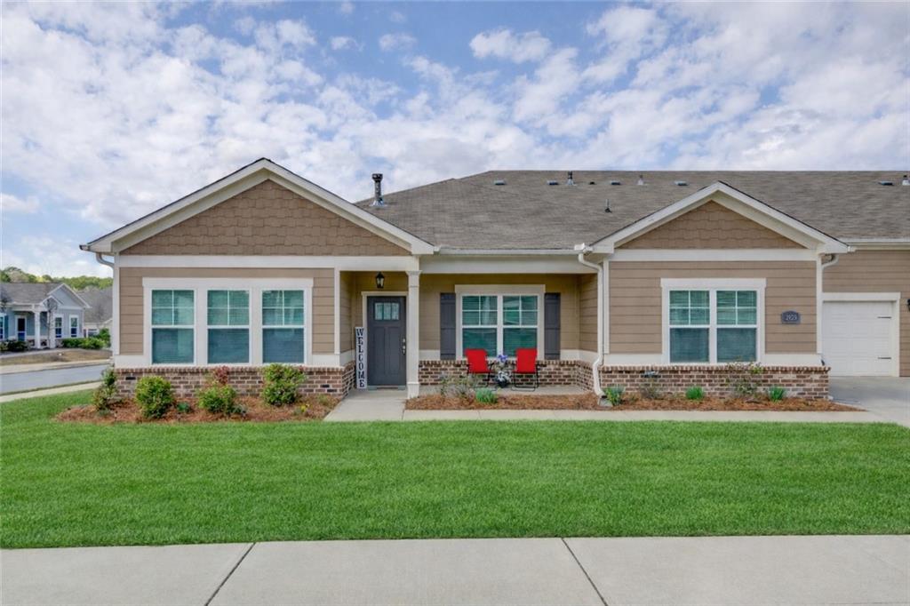 a front view of a house with a yard and trees
