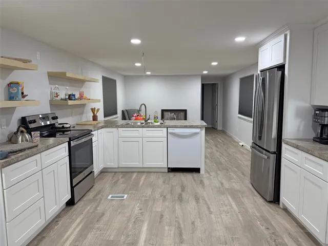 a kitchen with a sink stainless steel appliances and white cabinets