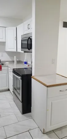 a kitchen with stainless steel appliances granite countertop a stove a microwave and a refrigerator