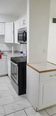 a kitchen with stainless steel appliances granite countertop a stove a microwave and a refrigerator