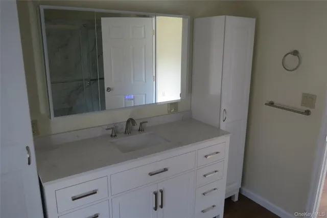 a bathroom with a granite countertop sink and mirror