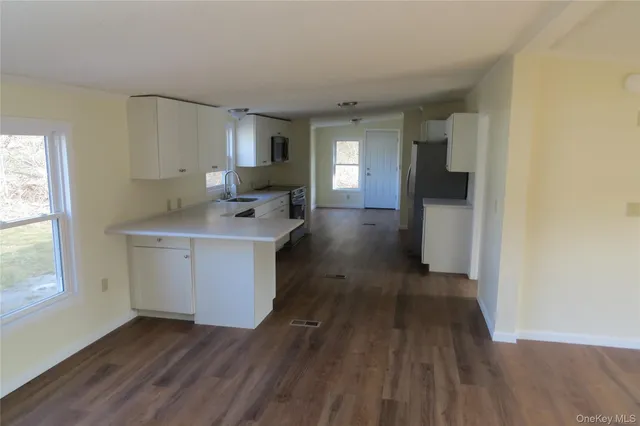 a view of a kitchen with wooden floor and electronic appliances