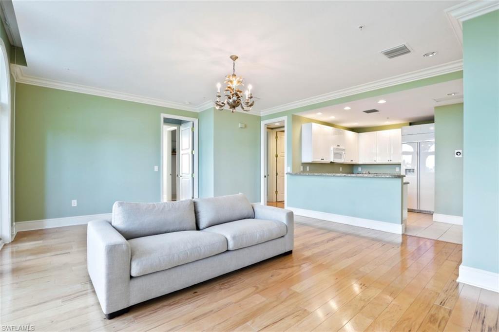 900 5th Avenue South, Unit 301 Naples, FL 34102 - Photo 5 of 17 a living room with furniture and a chandelier