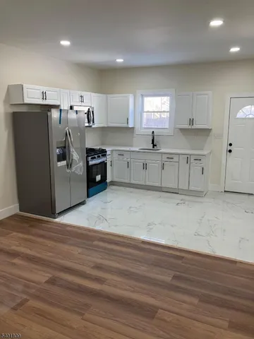 a kitchen with stainless steel appliances a refrigerator sink and stove
