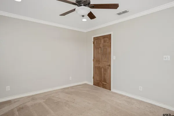 an empty room with a ceiling fan and painted walls