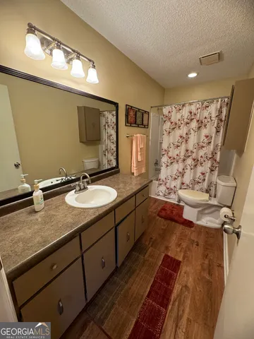 a bathroom with a granite countertop sink toilet and shower