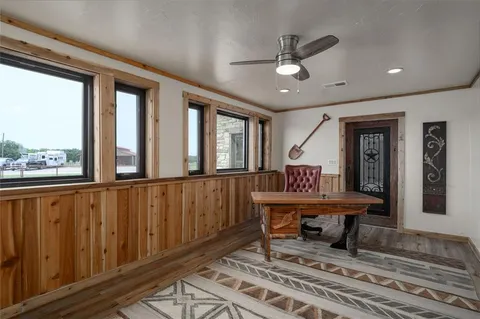 a bedroom with a bed ceiling fan and a large window