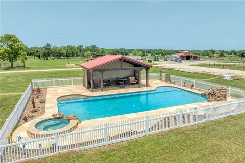 a view of a house with a yard and potted plants