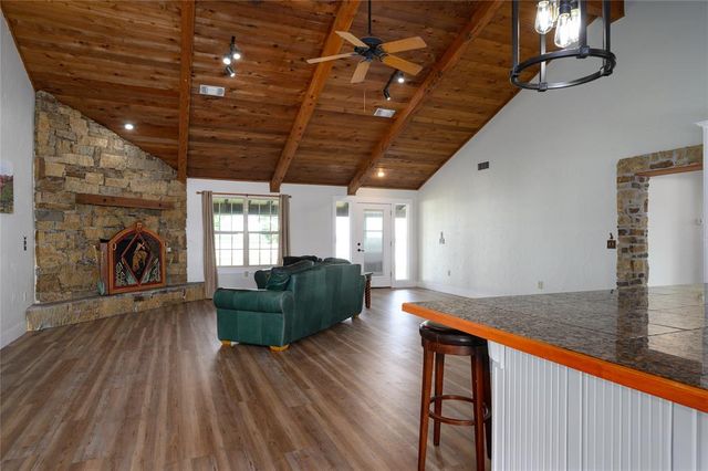 a kitchen with stainless steel appliances granite countertop a table chairs sink and cabinets