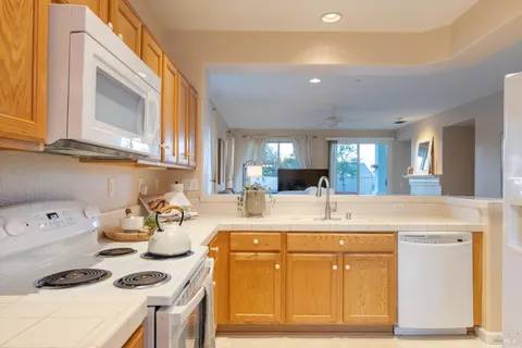 a kitchen with kitchen island a sink stove and white cabinets
