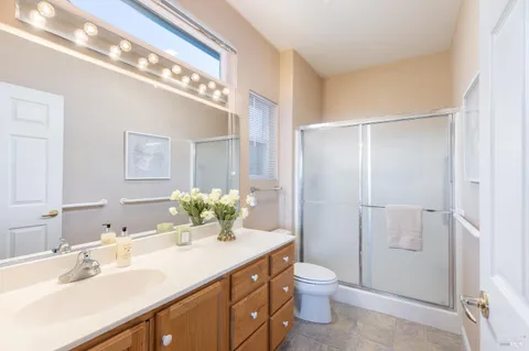 a bathroom with a double vanity sink mirror and toilet
