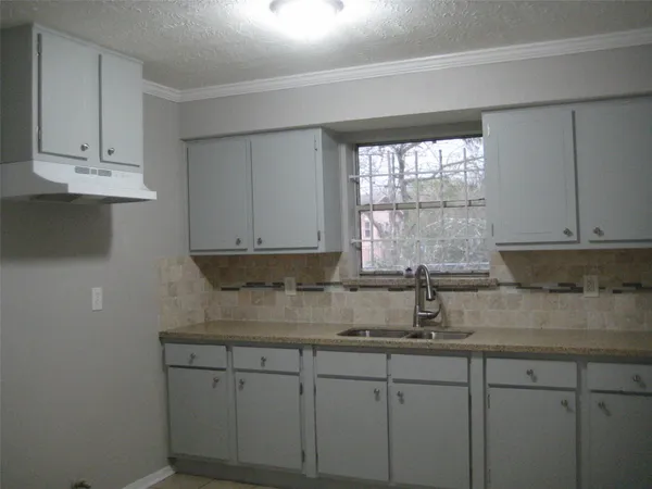 a kitchen with stainless steel appliances granite countertop white cabinets sink and window