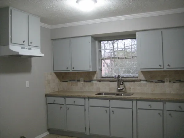a kitchen with stainless steel appliances granite countertop white cabinets sink and window