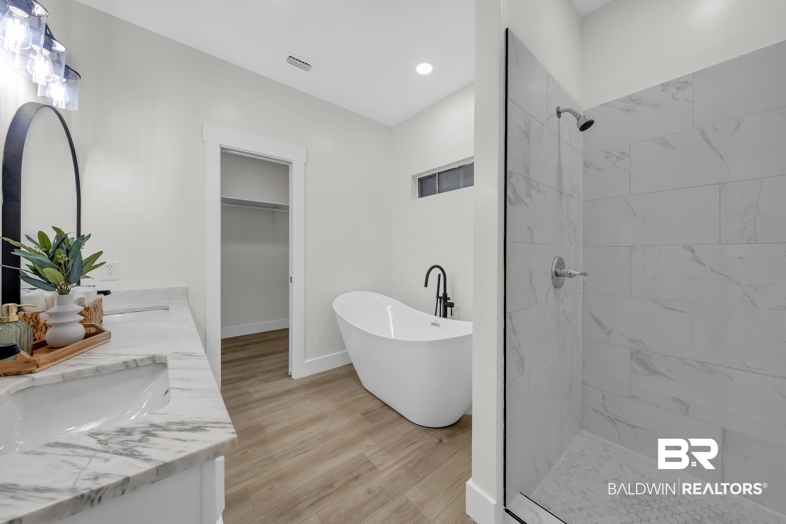 4924 Brooke Court Mobile, AL 36618 - Photo 23 of 34 Bathroom with a spacious closet, a freestanding tub, a shower stall, double vanity, and light wood finished floors