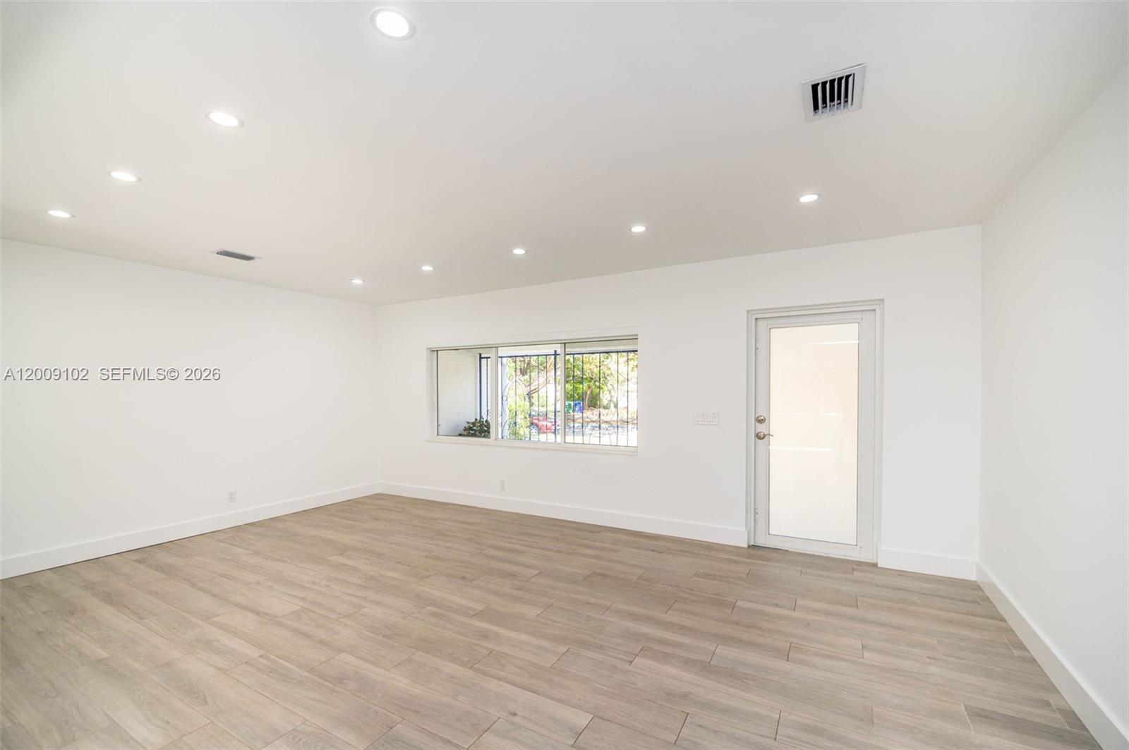330 Southwest 27th Road Miami, FL 33129 - Photo 5 of 62 an empty room with wooden floor and windows