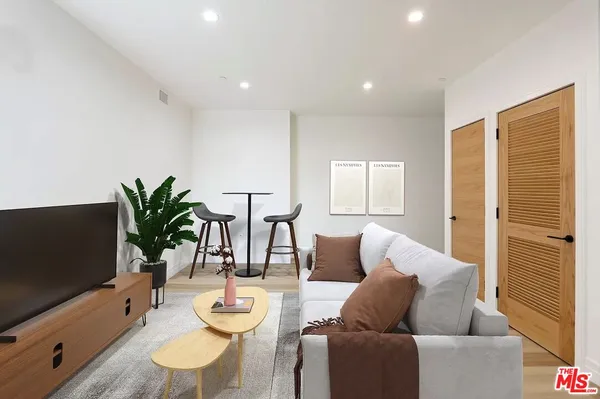 a living room with furniture potted plant and a flat screen tv