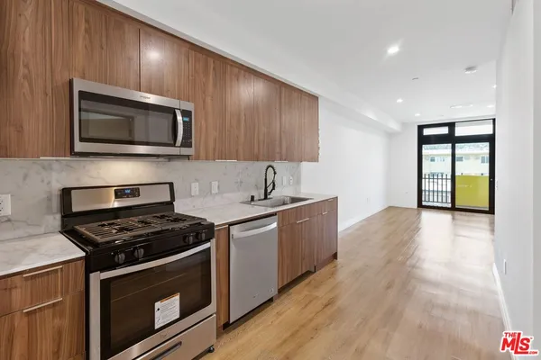 a kitchen with stainless steel appliances a stove microwave and sink