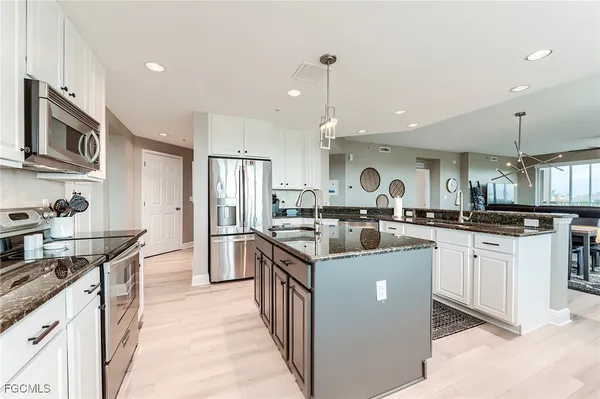 a kitchen with stainless steel appliances granite countertop a sink stove and refrigerator