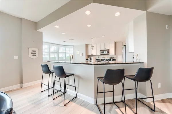 a kitchen with stainless steel appliances kitchen island granite countertop a stove a cabinets a sink and a island